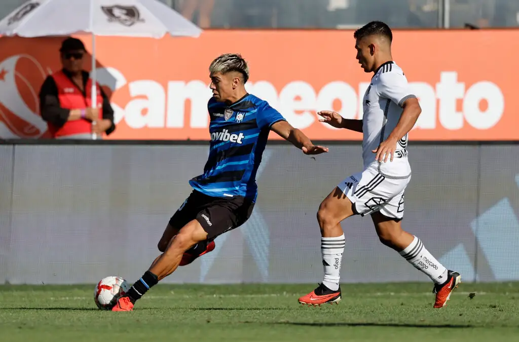 Maximiliano Gutierrez disputando el balón con Vicente Pizarro.