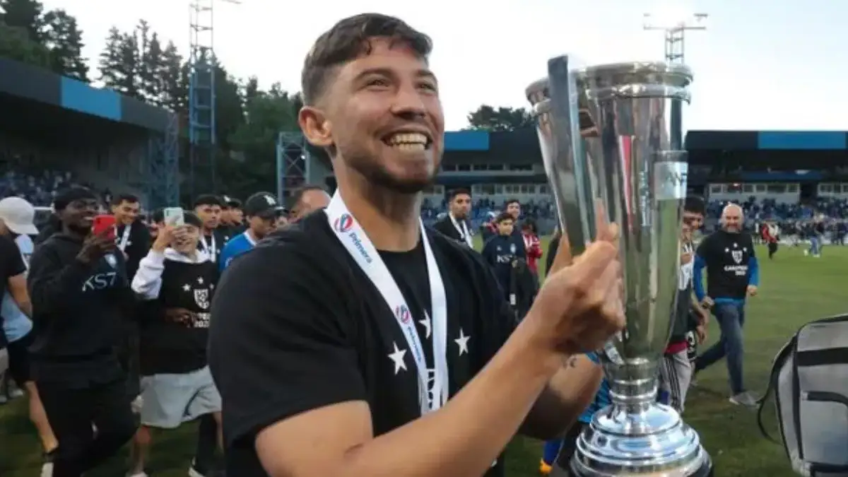 Felipe Loyola posando con el trofeo de campeón del fútbol chileno.