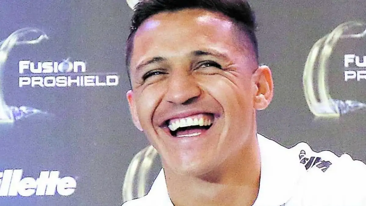 Primer plano a Alexis Sánchez sonriendo mientras entrega una conferencia de prensa con la camiseta del Olympique de Marsella.