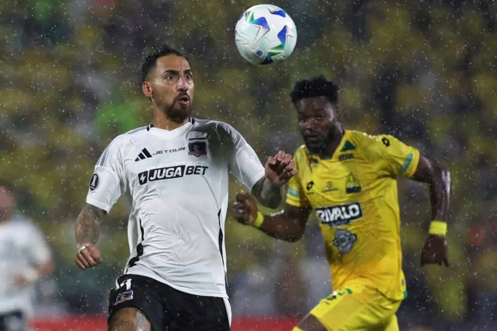 Javier Correa disputando un balón con un rival en duelo de Colo-Colo y Atlético Bucaramanga por Copa Libertadores.