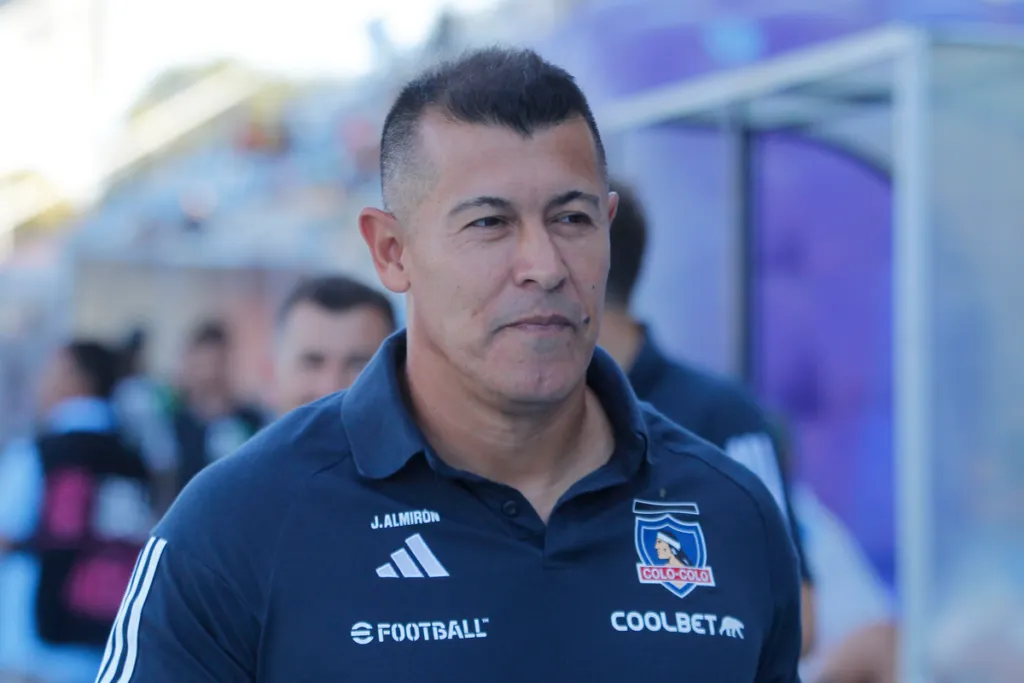 Jorge Almirón con una leve sonrisa en plano partido dirigiendo a Colo-Colo durante la temporada 2024.