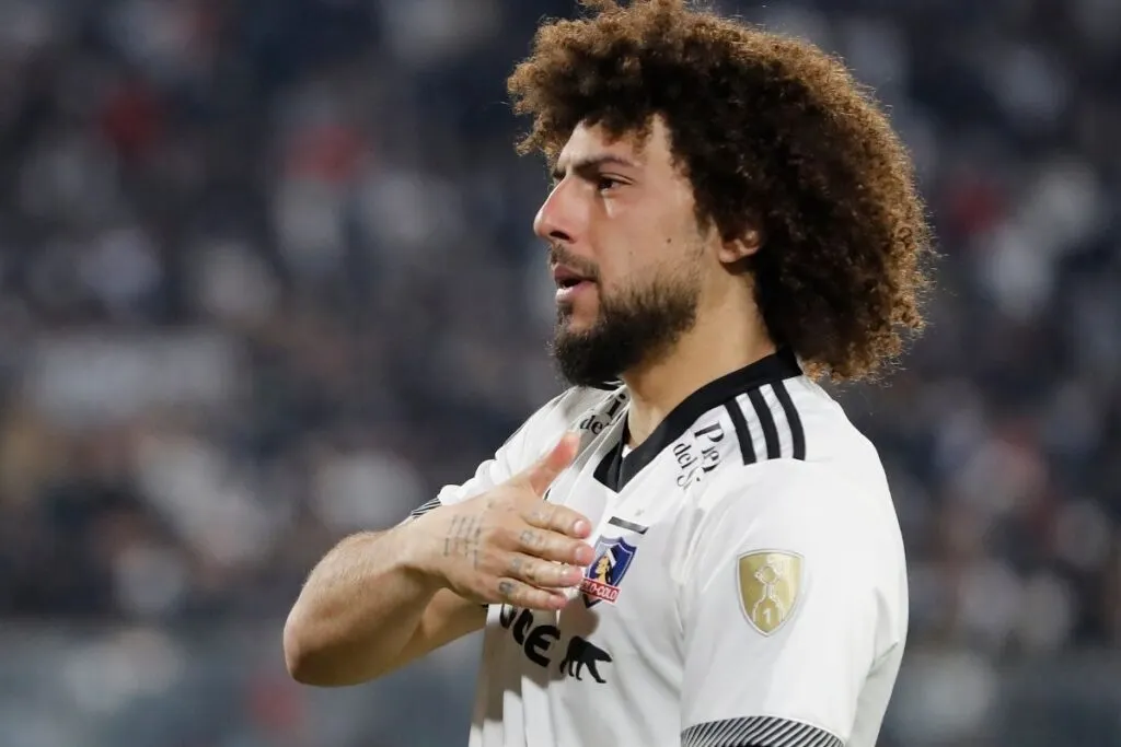 Primer plano a Maximiliano Falcón tocándose el escudo de Colo-Colo.