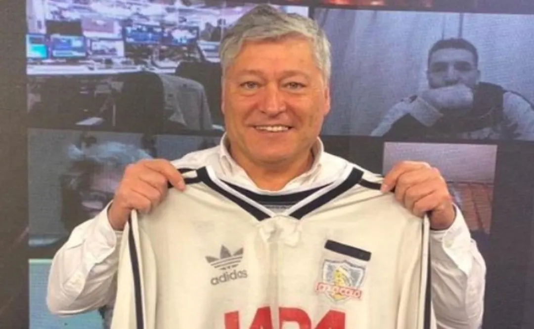 Patricio Yáñez sonriente con la camiseta de Colo-Colo 1991 en sus manos.