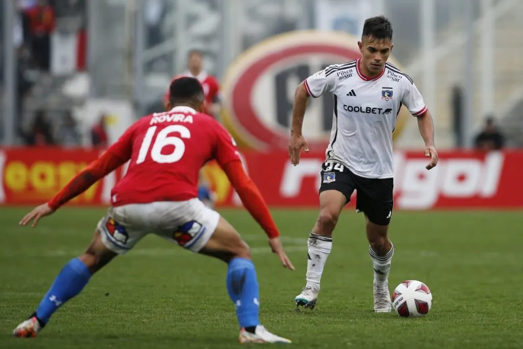 Vicente Pizarro con el balón, siendo marcado por Bryan Rovira en el partido de Colo-Colo vs Universidad Católica.