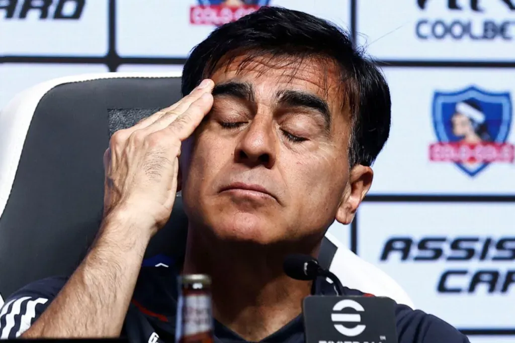 Primer plano de Gustavo Quinteros con los ojos cerrados y su mano en la frente