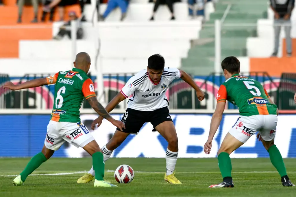 Damián Pizarro siendo marcado por Alejandro Camargo y Francisco Alarcón.