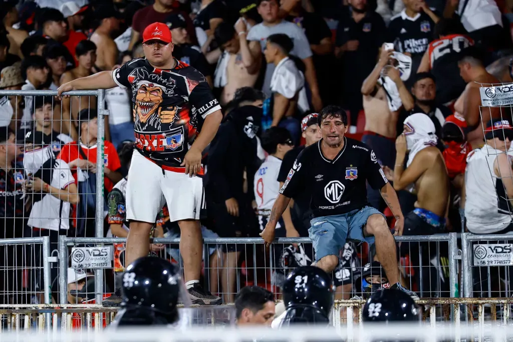 Hinchas de Colo-Colo sobre una de las rejas del Estadio Nacional.