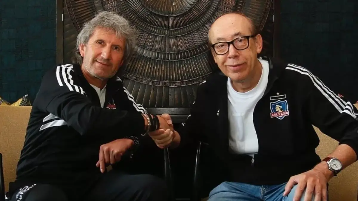 Daniel Morón y Alfredo Stöhwing dándose la mano con indumentaria de Colo-Colo.