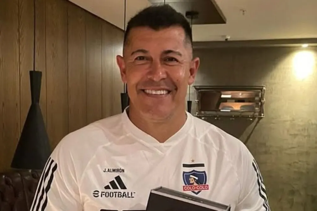 Primer plano de Jorge Almirón sonriente con camiseta de Colo-Colo.