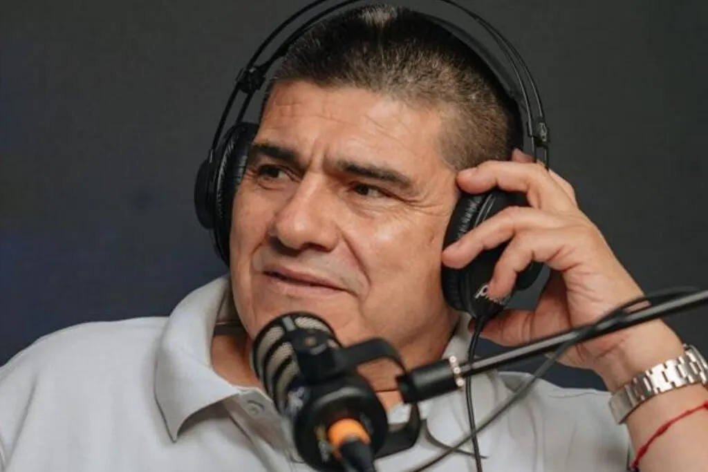 Primer plano a Marcelo Vega hablando a un micrófono con audífonos en las orejas.