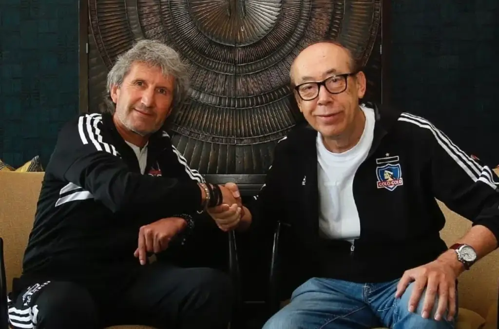 Daniel Morón y Alfredo Stöhwing dándose la mano con indumentaria de Colo-Colo.