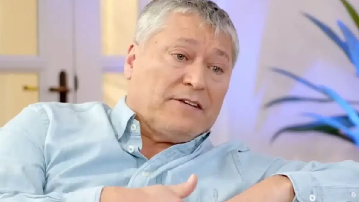 Patricio Yáñez concediendo una entrevista en un sillón con una camisa azul.