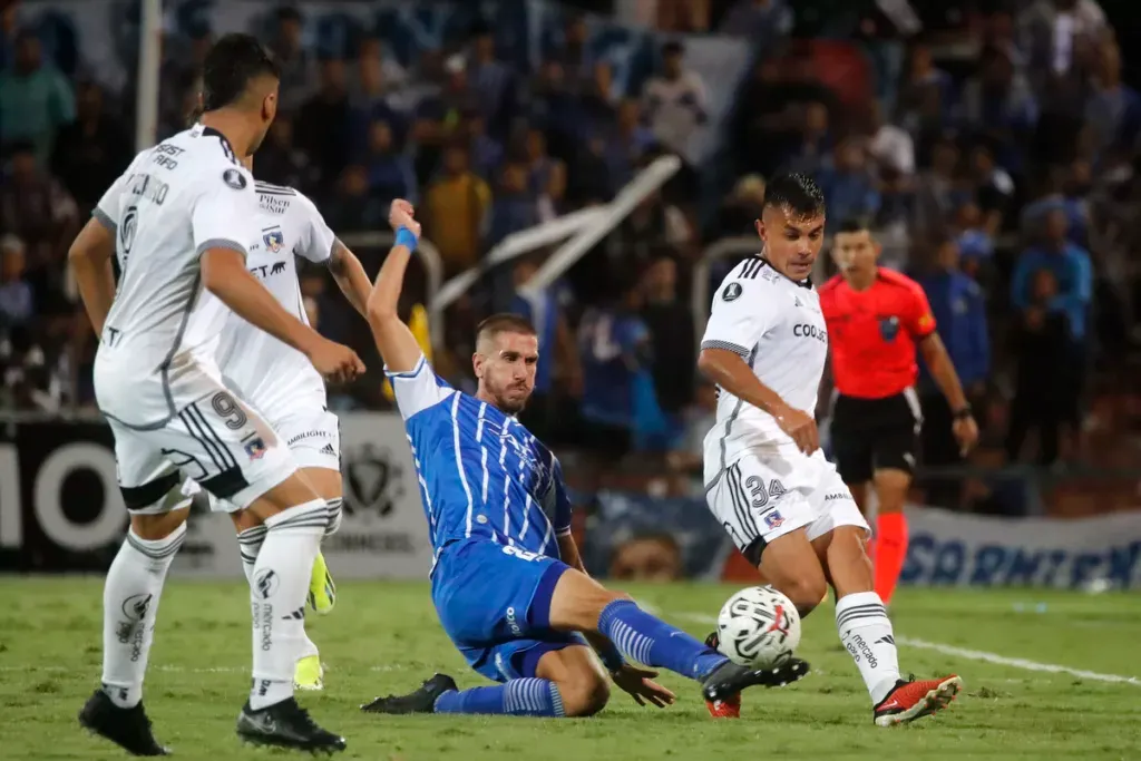 Jugador de Godoy Cruz peleando un balón con jugadores de Colo-Colo.