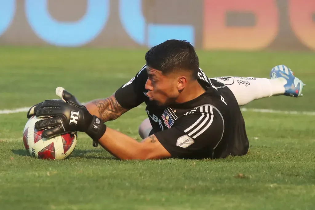 Brayan Cortés atajando un balón en pleno partido con la camiseta de Colo-Colo durante la temporada 2023.