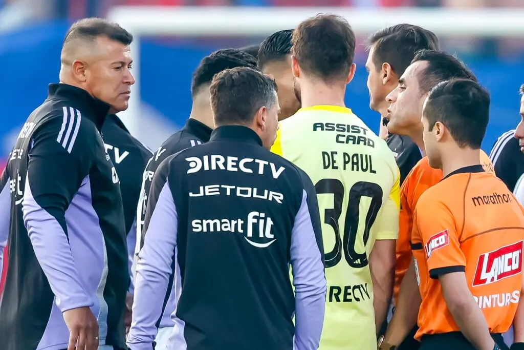Almirón junto al árbitro Piero Maza.